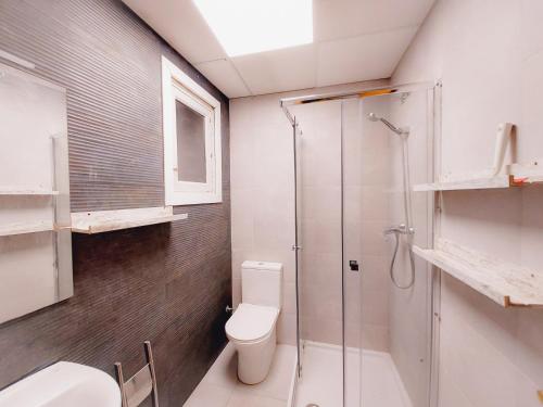 a bathroom with a toilet and a glass shower at Alojamiento San Juan en Murcia Centro in Murcia