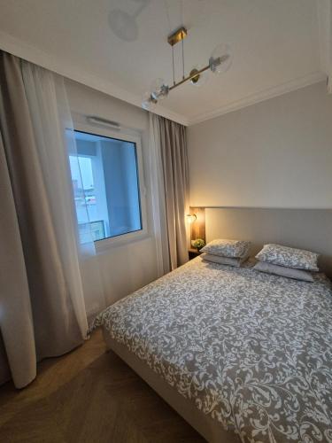 a bedroom with a bed and a window at STARCO Apartamenty obok dworca in Stargard