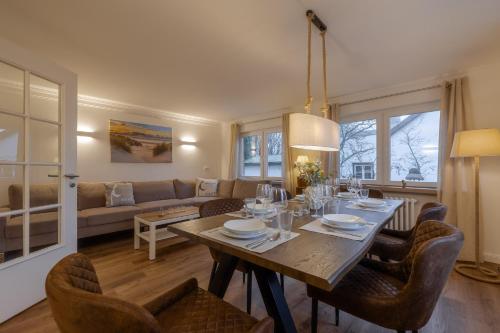 a dining room and living room with a table and chairs at Ankerplatz Sylt in Sylt