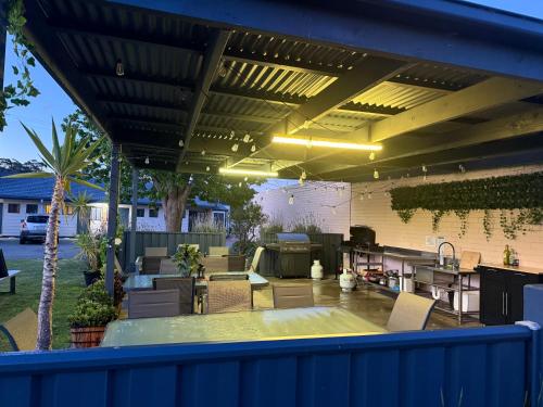 a patio with a table and chairs under awning at Lakeside Motel Waterfront in Lakes Entrance