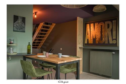 ein Esszimmer mit einem Tisch und grünen Stühlen in der Unterkunft Cachoire in Tournai