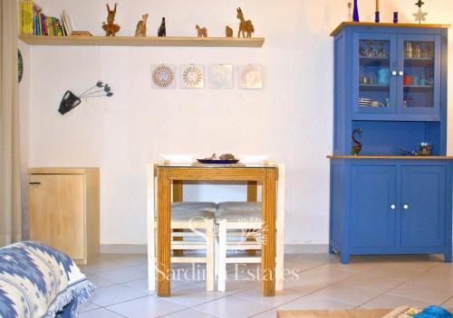 a room with a table and a blue cabinet at Fronte spiaggia con parcheggio - Rainbow House in Porto Rotondo