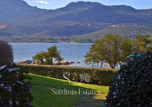 a view of a lake with mountains in the background at Fronte spiaggia con parcheggio - Rainbow House in Porto Rotondo