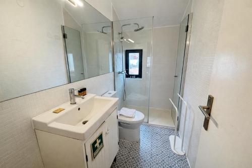 a bathroom with a sink and a shower and a toilet at Oporto City View - Trindade in Porto