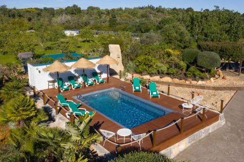 an aerial view of a pool with chairs and a deck at VILLA CARACOL with Heated Pool & Mini-Golf in Luz de Tavira