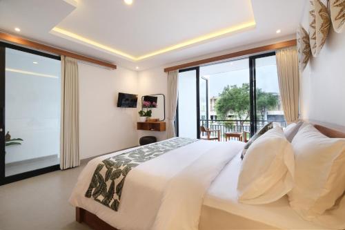 a bedroom with a large bed and large windows at Emerald Villas Canggu in Canggu