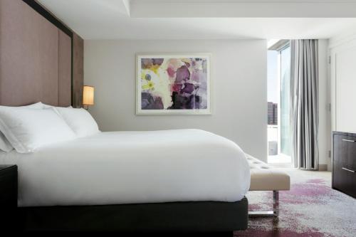 a bedroom with a white bed and a large window at Loews Atlanta Hotel in Atlanta