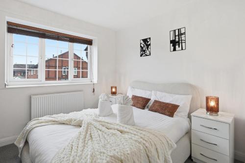 a white bedroom with a bed and a window at Modern Refurbished 2 Bed House Ideal for Business & Families in Newton Road Station