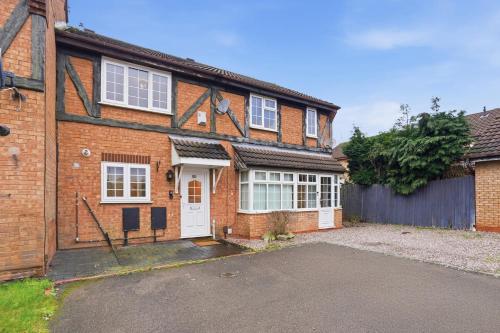 a brick house with a white door and a driveway at Modern Refurbished 2 Bed House Ideal for Business & Families in Newton Road Station