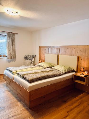 a large bed in a bedroom with a wooden headboard at Ferienwohnung Mariengrund in Schönau am Königssee