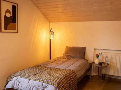 a bedroom with a bed and a table with a lamp at Landhaus Kummerfrei in Hellenthal
