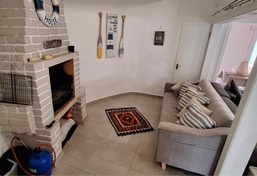 a living room with a couch and a fireplace at Die Boomhuis. Pearly Beach in Pearly Beach
