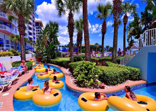 a group of people in tubes in a pool at a resort at Wyndham Ocean Walk 703 - Vacation in Comfort and luxury 1BR Oceanfront in Daytona Beach