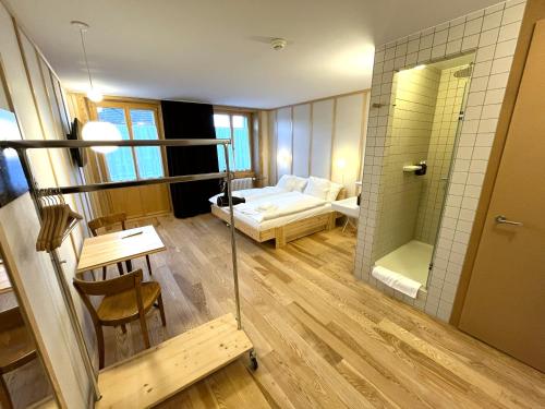 a small room with a bed and a bathroom at Hôtel de la Maison de la Tourbière in Les Ponts-de-Martel