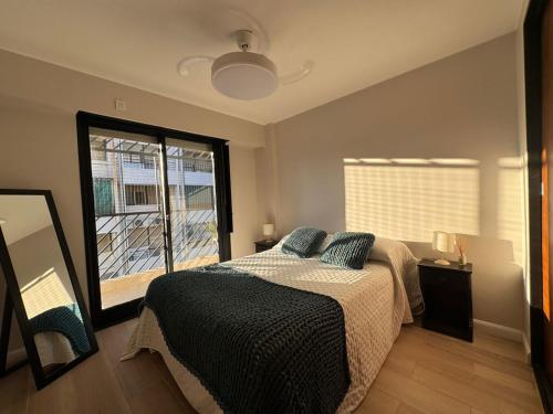 a bedroom with a bed and a large window at En el Corazón de Rosario in Rosario