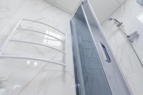 a shower with a glass door in a bathroom at Seven Apart Hotel in Vyshneve