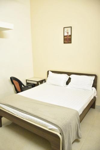 a bed with white sheets and pillows in a room at GA Fernandes house in Colva