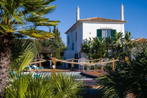 a house with a pool in front of a building at VILLA CARACOL with Heated Pool & Mini-Golf in Luz de Tavira