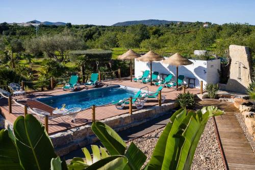 an outdoor swimming pool with chairs and umbrellas at VILLA CARACOL with Heated Pool & Mini-Golf in Luz de Tavira