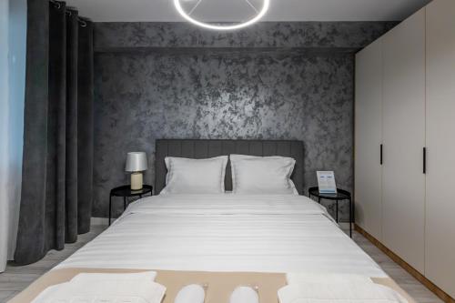 a bedroom with a large bed with white sheets at Rezidential Bacovia Orange by Rooms in Bacău