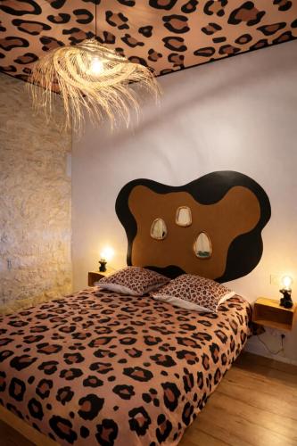a bedroom with a bed with a cheetah headboard at Studio Savane - 5 min du Zoo - CLIM in Seigy