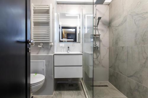 a bathroom with a toilet and a sink and a shower at Rezidential Bacovia Orange by Rooms in Bacău