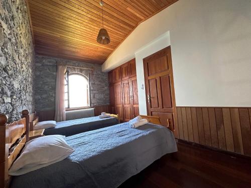 a bedroom with two beds and a window at Kofinas villa Evdilos by BRP-PROPERTIES in Evdilos