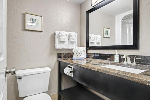 a bathroom with a toilet and a sink and a mirror at The Patricia Grand in Myrtle Beach