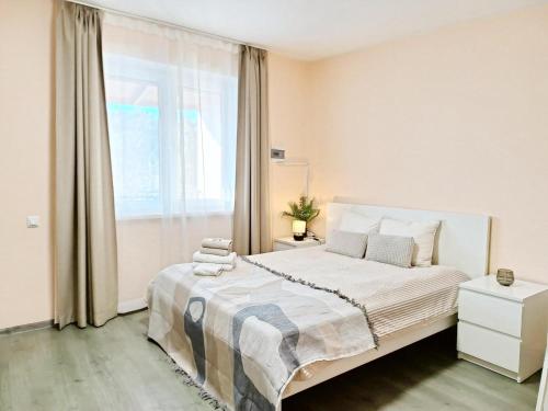 a bedroom with a large bed and a window at Dunes Trail 3 in Melnragė