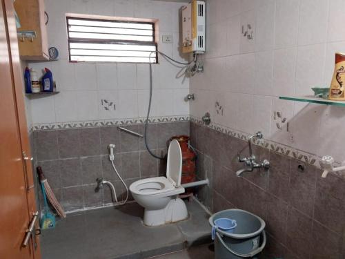 a small bathroom with a toilet and a shower at Saraswati Sadan in Hospet