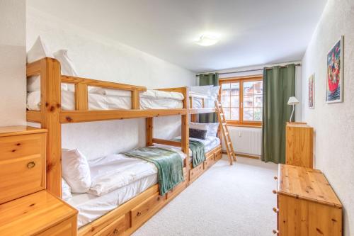 a bedroom with two bunk beds and a desk at Centrally located with great views and terrace in Champéry