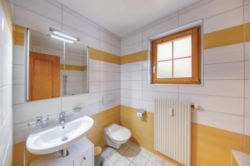a bathroom with a sink and a toilet and a window at Centrally located with great views and terrace in Champéry
