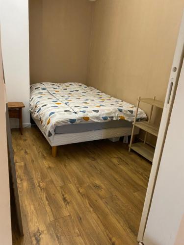a small bedroom with a bed and a wooden floor at Appartement climatisé 1 à 4 personnes avec belle terrasse in Vidauban