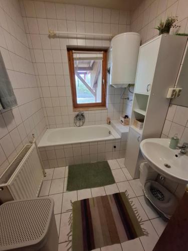a small bathroom with a tub and a sink at Rigó Nyaralóház in Lakitelek