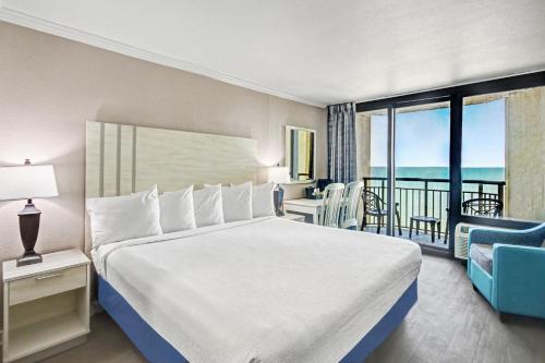 a bedroom with a bed and a balcony with the ocean at The Patricia Grand in Myrtle Beach