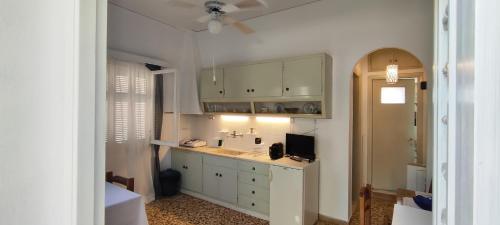 a kitchen with white cabinets and a sink at Dandelion Paros Apartments IV in Kóstos