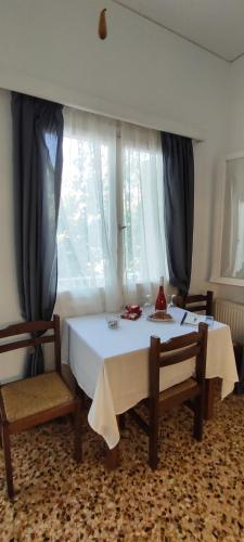 a room with a table and two chairs and a window at Dandelion Paros Apartments IV in Kóstos