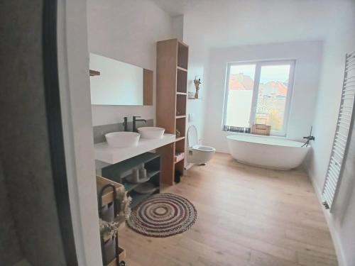 a bathroom with two sinks and a bath tub at Mi casa es su casa in Ghent