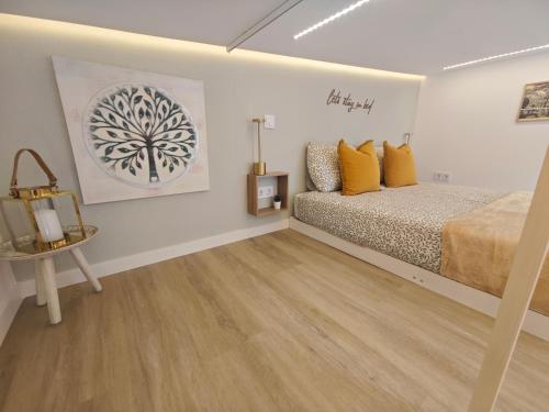 a bedroom with a bed with yellow pillows and a table at Galamares Nest in Sintra