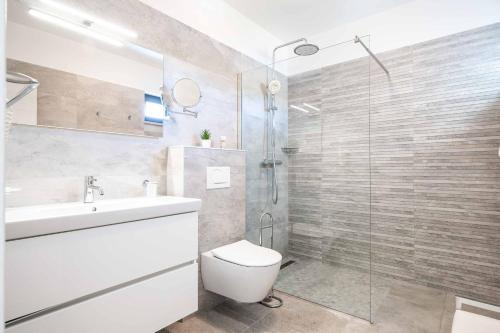 a bathroom with a toilet and a glass shower at Villa High Life in Seget Vranjica
