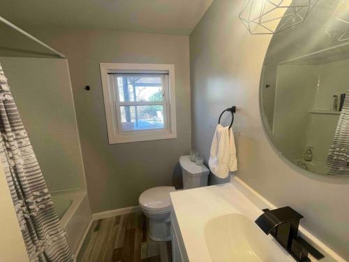 a bathroom with a sink and a toilet and a mirror at The Beach Gallery in Narragansett