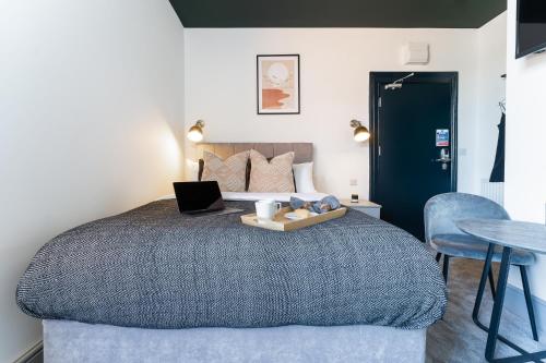 a bedroom with a bed with a laptop on it at The Madison - Premium Self Check-In Studios & Apartments in Southampton