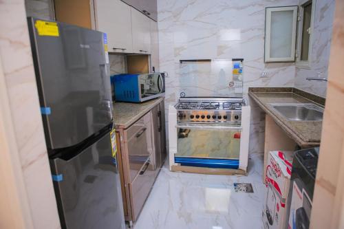a small kitchen with a stove and a microwave at الزقازيق in Kafr Muḩammad Ḩusayn