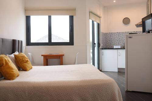 a bedroom with a large white bed with yellow pillows at Faial Marina Apartments 1 in Horta