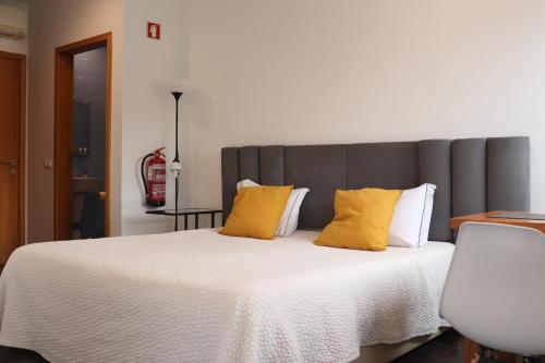 a bedroom with a large bed with yellow pillows at Faial Marina Apartments 1 in Horta