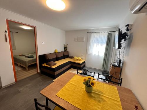 a living room with a table and a couch at Kicsi Rigó Nyaralóház in Lakitelek