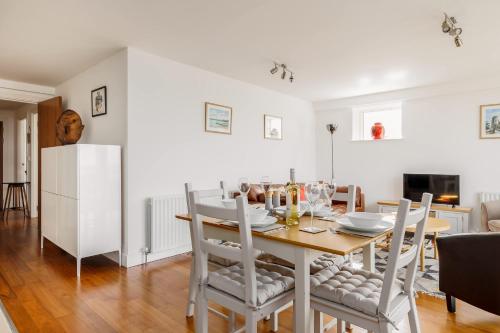 a kitchen and dining room with a table and chairs at A Wave From It All - Extensive Harbour Views from Wrap-Around Balcony in Poole
