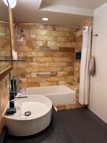 a bathroom with a tub and a toilet and a sink at The Tudor Arms Hotel Cleveland - a DoubleTree by Hilton in Cleveland