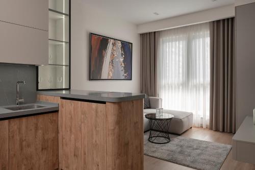 a kitchen with a counter and a living room at STYLO Residences & Suites in Tashkent