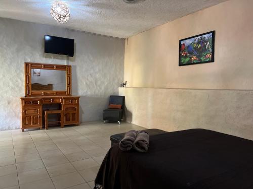 a bedroom with a bed and a desk and a mirror at Calli Hotel Tepoztlán in Tepoztlán